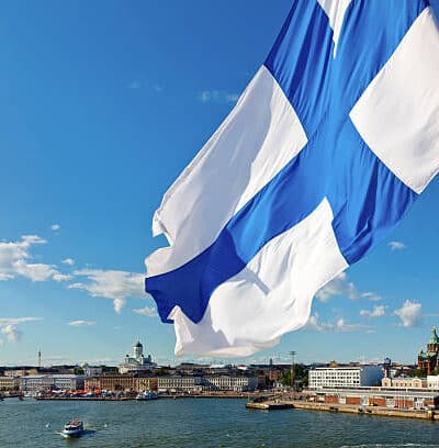 Suomen lippu liehuu taustallaan Helsingin kaupungin siluetti