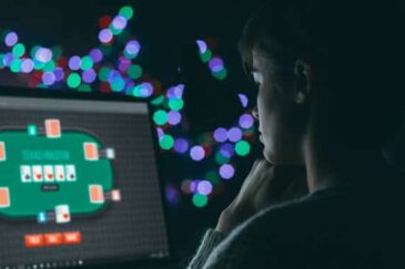 Pimeässä huoneessa on tietokoneen näyttö, jossa näkyy nettipokeripöytä. Tietokoneen edessä on nuori mies. Taustalla on valoja.