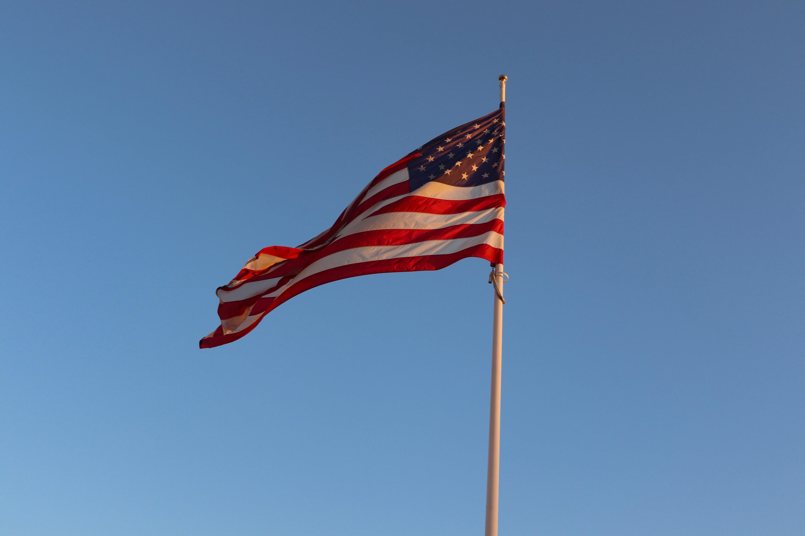 Yhdysvaltojen lippu liehuu sinistä taivasta vasten