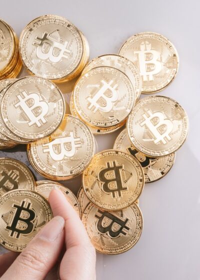 Bitcoin-kryptovaluuttaa kuvaavia kultaisia kolikoita kasassa