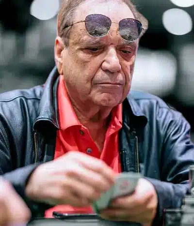 John Cernuto pokeripöydän ääressä punaisessa paidassa ja sinisessä takissa. Cernuto menehtyi 2025.