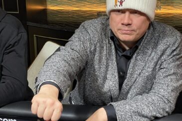 Ilari Sahamies istuu pokeripöydässä varastettu puvuntakki päällään ja Myrttisen suolakurkkujen pipo päässään