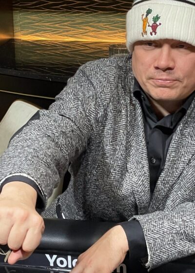 Ilari Sahamies istuu pokeripöydässä varastettu puvuntakki päällään ja Myrttisen suolakurkkujen pipo päässään