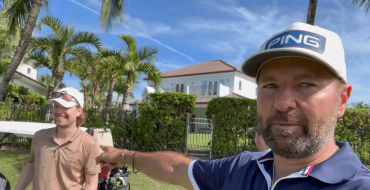 Kuvassa on kaksi miestä, molemmilla on valkoinen lippis. Toinen miehistä osoittaa toista sormella, taustalla näkyy sinistä taivasta ja palmupuita.