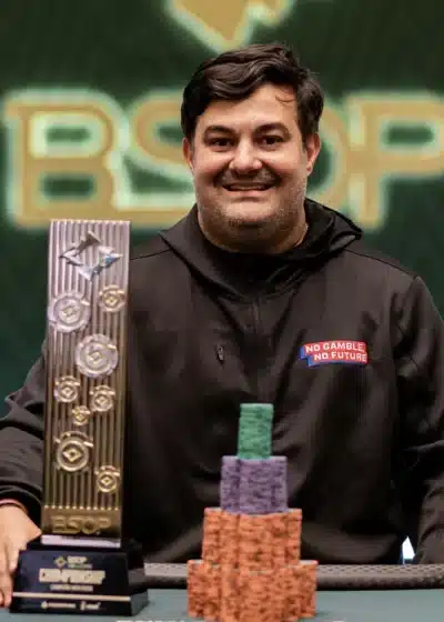 Alen Fillipi pokaali kädessään ja pelimerkkejä edessään