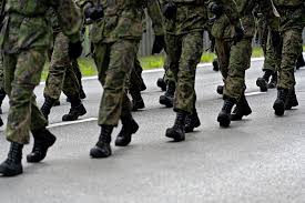 Varusmiehet marssimassa sotilasasuissa, vain jalat ja maiharit näkyvissä