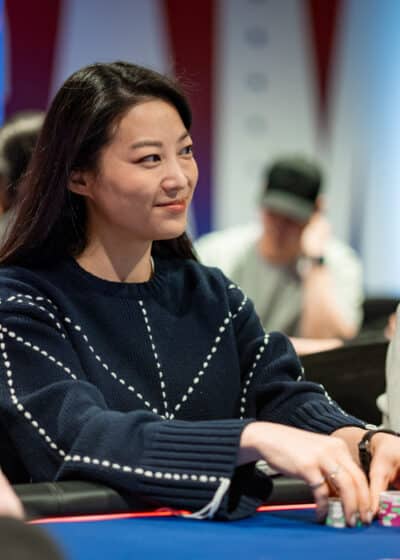 Nainen mustassa paidassa istuu pokeripöydän ääressä.