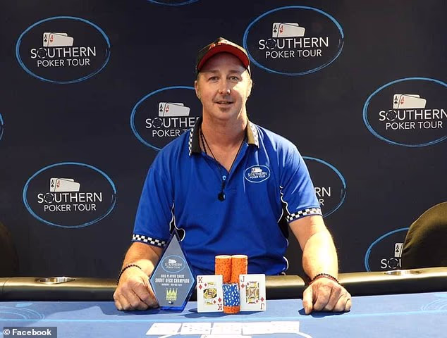 Mies sinisessä paidassa poseeraa voittajakuvassa pokeripöydän äärellä.