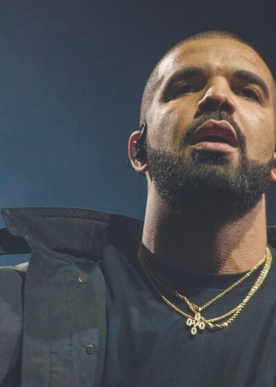 Yhdysvaltalaisräppäri Drake poseeraa mustassa asussa kädet levällään