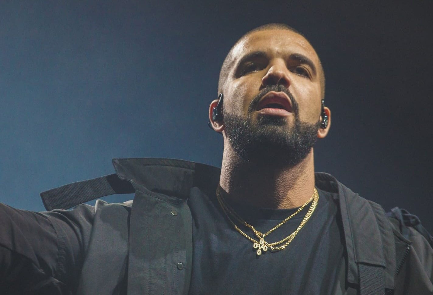 Yhdysvaltalaisräppäri Drake poseeraa mustassa asussa kädet levällään