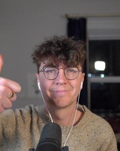 Kuvassa tunnettu striimaaja ja videoiden tekijä Fintant Hand, kuva otettu Web kameralla ja kuulokkeet korvilla, sekä mikrofoni edessä.