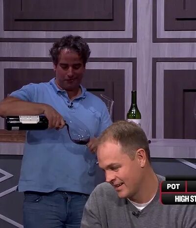 Kuvassa high stakes pelaaja Justin Gavri kaataa itselleen punaviiniä samalla kun kortteja jaetaan pöytään.