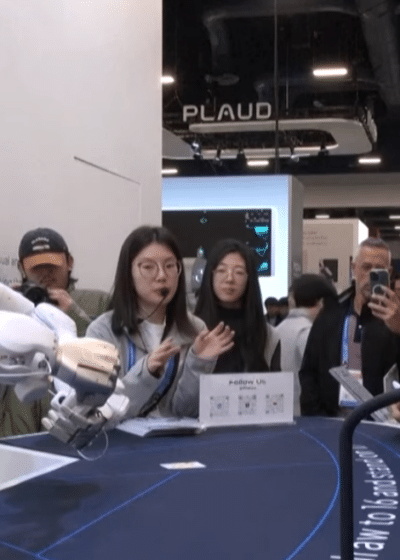 Kuvassa on valkea humanoidirobotti, joka jakaa pelikortteja pelipöydän ääressä.