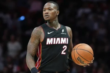 Koripallon pelaaja mustassa pelipaidassa, jonka etupuolella lukee "Miami"