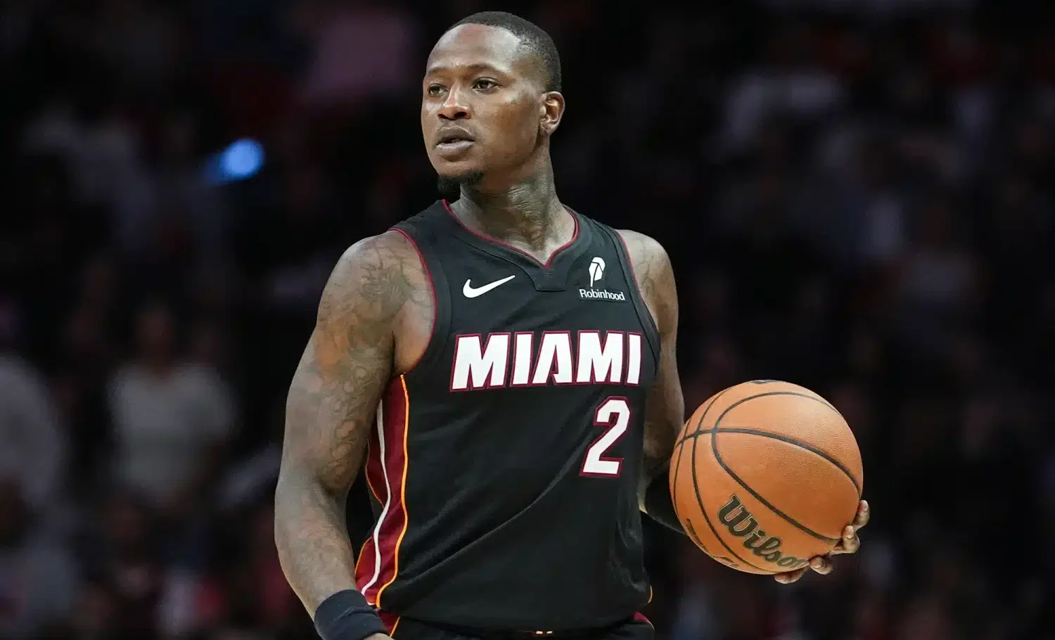 Koripallon pelaaja mustassa pelipaidassa, jonka etupuolella lukee "Miami"