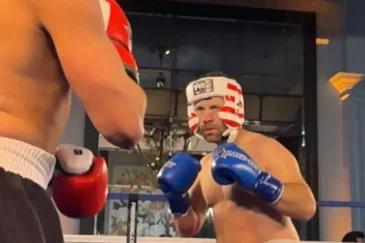 Daniel "Jungleman" Cates seisoo ilman paitaa nyrkkeilykehässä. Hänellä on päässään kypärä ja käsissään nyrkkeilyhanskat.