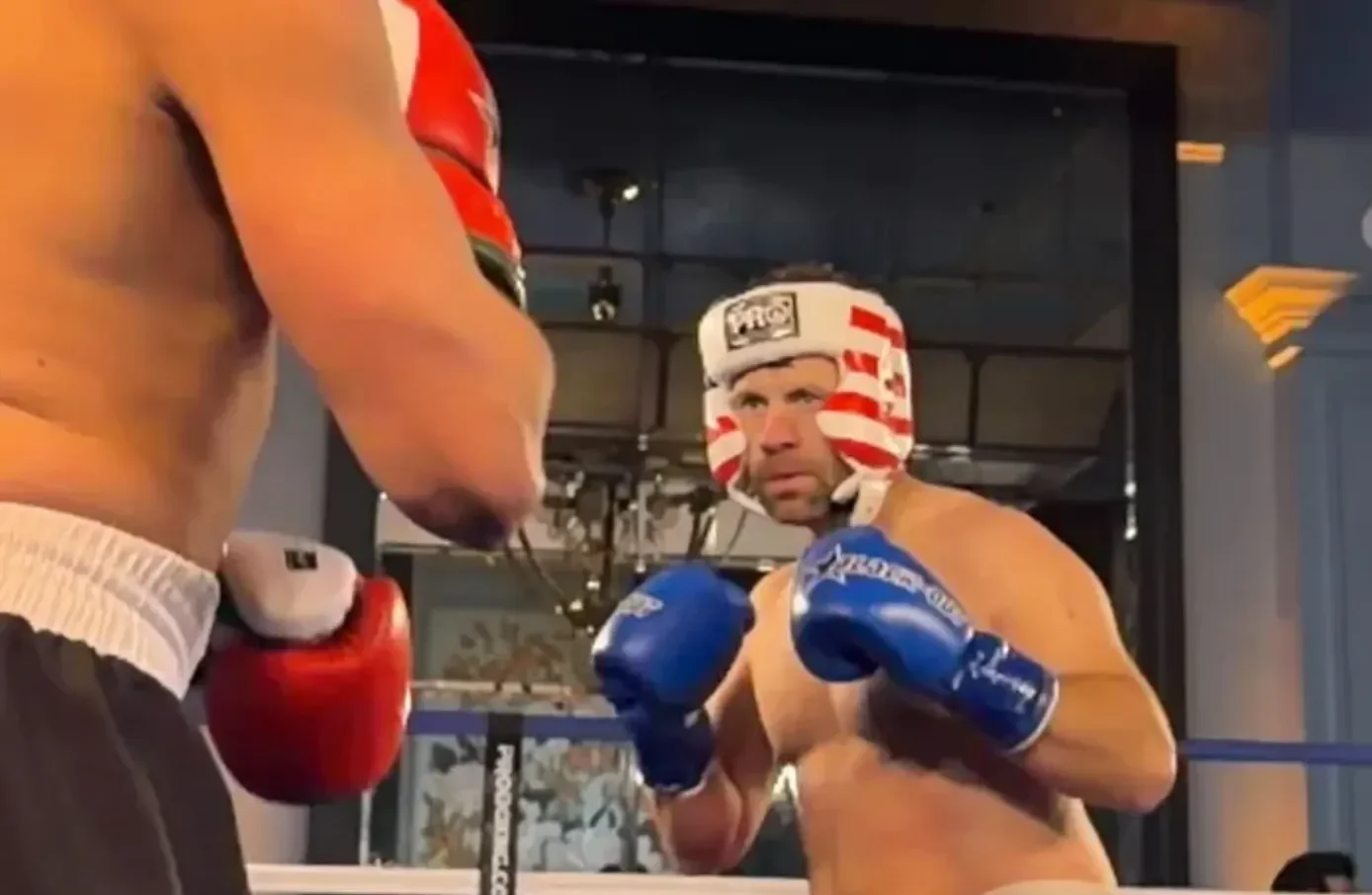 Daniel "Jungleman" Cates seisoo ilman paitaa nyrkkeilykehässä. Hänellä on päässään kypärä ja käsissään nyrkkeilyhanskat.