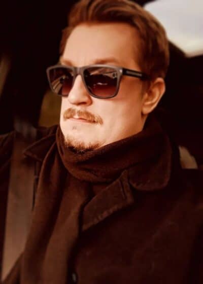 Arttu "Olvari" Hämäläinen istuu aurinkolasit päässään autossa