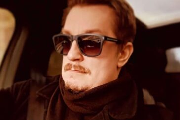 Arttu "Olvari" Hämäläinen istuu aurinkolasit päässään autossa