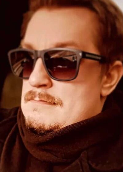 Arttu "Olvari" Hämäläinen istuu aurinkolasit päässään autossa