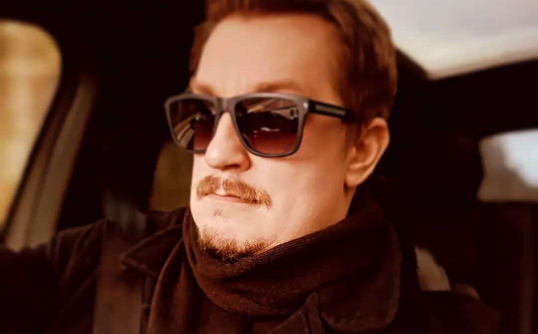 Arttu "Olvari" Hämäläinen istuu aurinkolasit päässään autossa