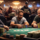 Pokeripöydän ääressä istuu kome miestä, taustalla on useita henkilöitä. Pöytä on vihreä ja siinä on useita pelimerkkejä ja kortteja.
