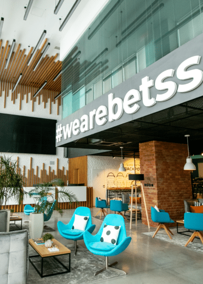 Kuvassa näkyy Betssonin toimisto, jossa kirkkaan siniset penkit ja modernia arkkitehtuuria