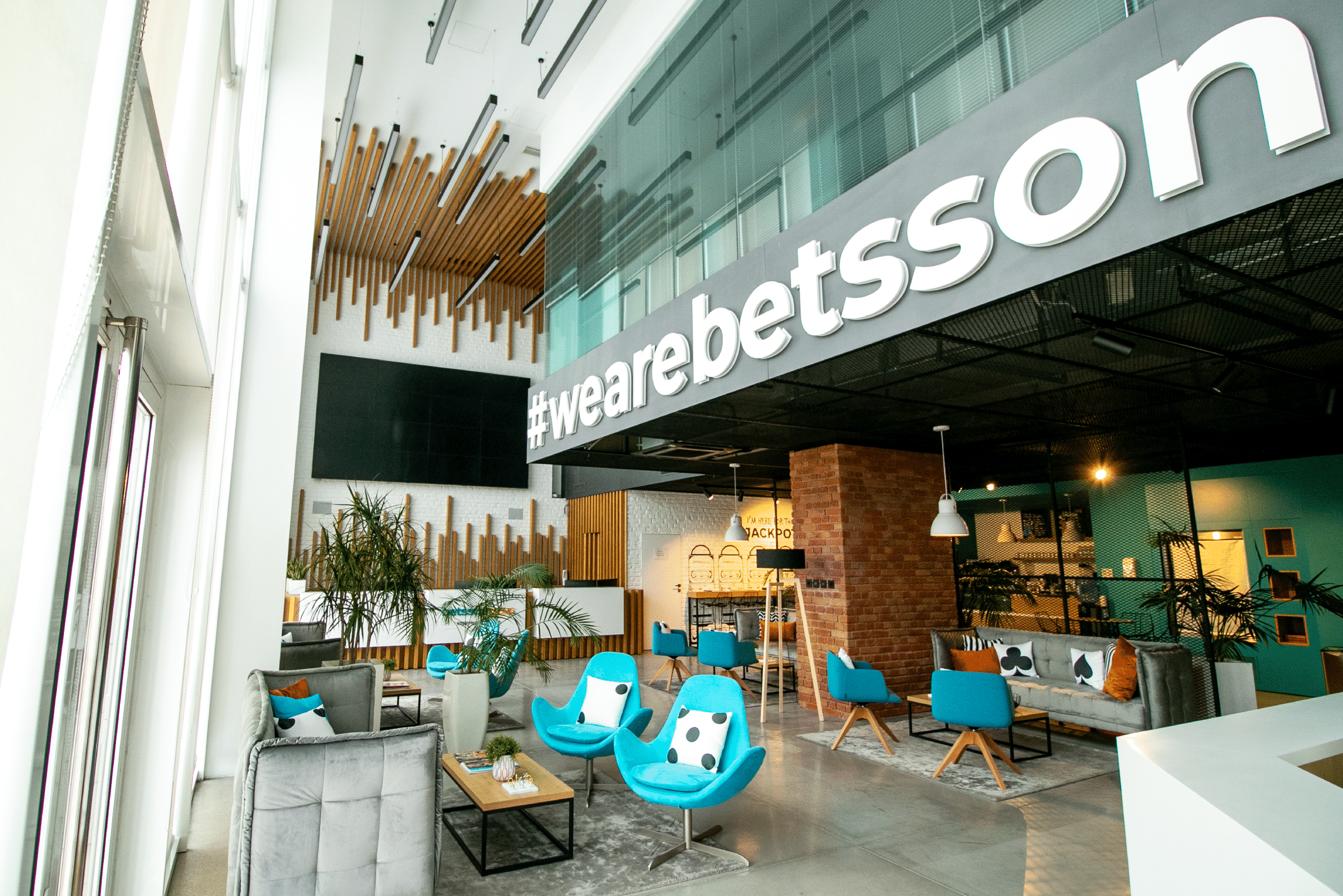 Kuvassa näkyy Betssonin toimisto, jossa kirkkaan siniset penkit ja modernia arkkitehtuuria