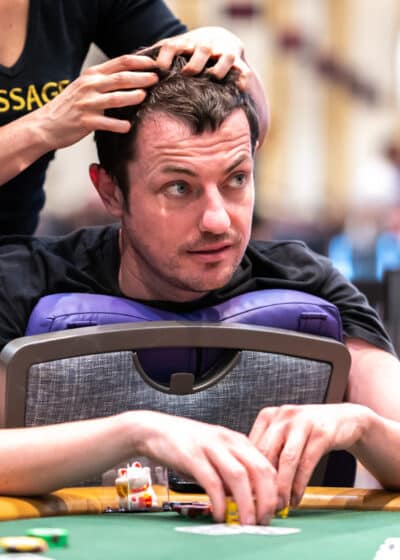 Tom Dwan saamassa hierontaa pokeripöydässä