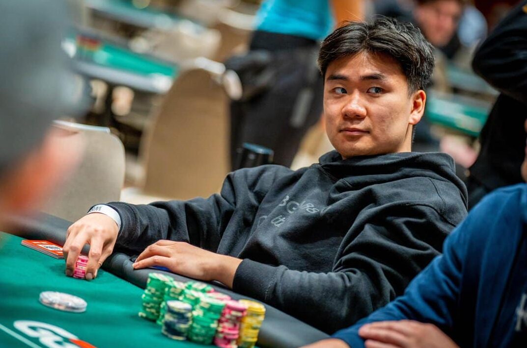 Hengtao Zhu istuu pokeripöydän ääressä harmaassa hupparissa