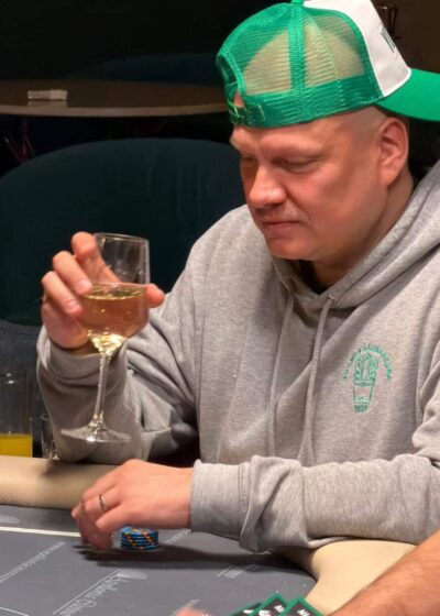 Ilari Sahamies pokeripöydän ääressä viinilasi kädessään