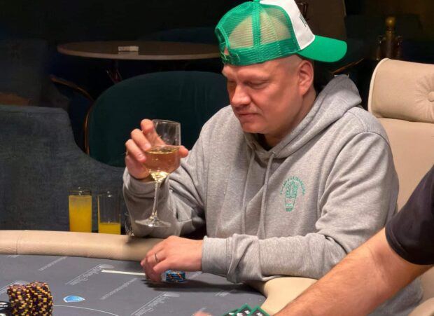Ilari Sahamies pokeripöydän ääressä viinilasi kädessään