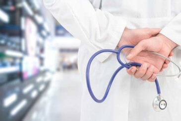 Lääkäri kävelee kädet selän takana stetoskooppi kädessään