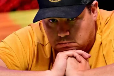 Pokerinpelaaja Shaun Deep masentuneena ketlaisessa paidassa ja lippis päässään