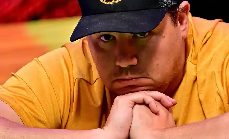 Pokerinpelaaja Shaun Deep masentuneena ketlaisessa paidassa ja lippis päässään