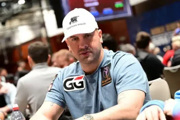 Michael Mizrachi pokeripöydässä lippis päässään ja vaalenansinisessä T-paidassa