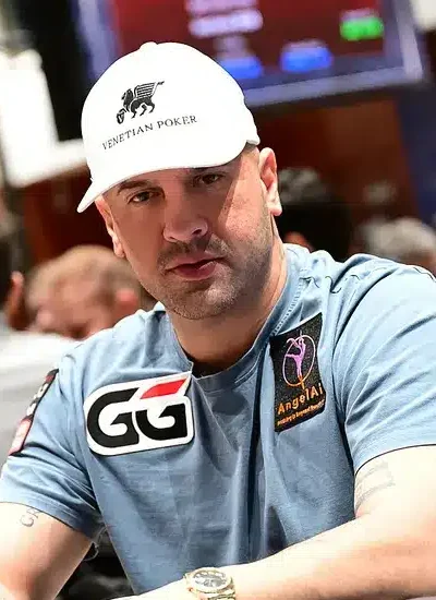Michael Mizrachi pokeripöydässä lippis päässään ja vaalenansinisessä T-paidassa